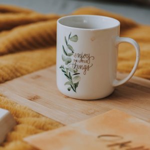 Enjoy a tranquil morning with this motivational coffee mug on a cozy blanket, perfect for peaceful reflection.