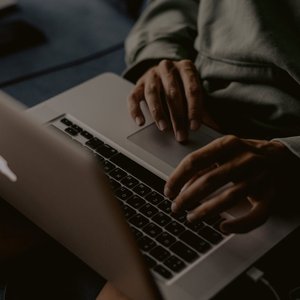 Close-up of hands typing on a laptop indoors, perfect for work-from-home themes.