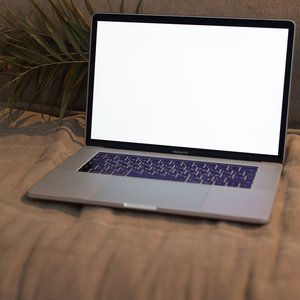 Open laptop with blank screen on a comfortable sofa, perfect for mockup presentations.