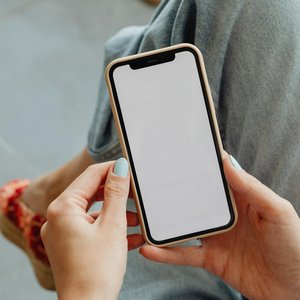 Woman holding smartphone with blank screen, perfect for app mockups or design presentations.