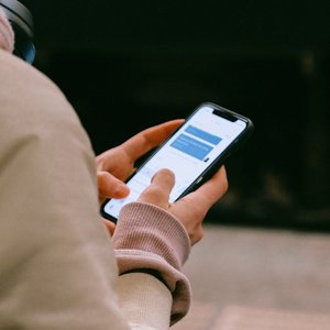 A person using a smartphone for texting, focusing on their hands and device screen.