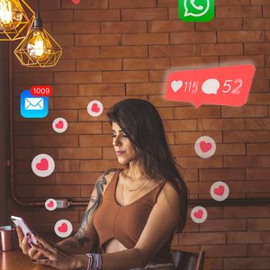 Woman using smartphone in cafe with social media notifications around.