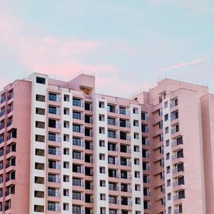 A low angle view of a modern high-rise office building against a pastel sky at dusk.