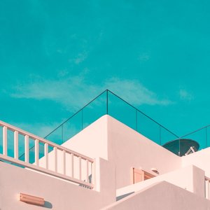 Explore the clean lines of modern Cycladic architecture under a clear blue sky in Platis Gialos, Greece.