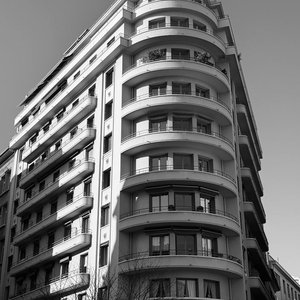Classic black and white photo showcasing an elegant curved facade of a city building.
