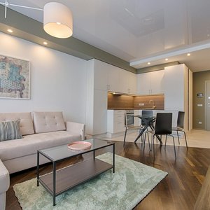 Spacious modern living room featuring chic furniture, stylish decor, and a minimalist kitchen.