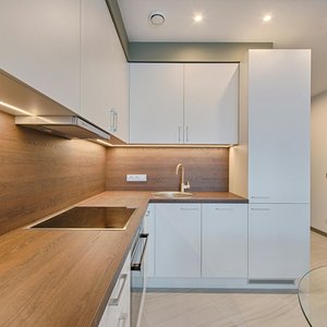 Modern kitchen interior with minimalistic design and wooden accents, captured with natural lighting.