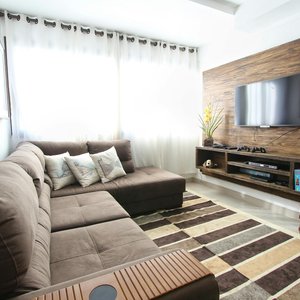 Stylish modern living room featuring a brown sofa, wall-mounted TV, and interior decor.