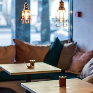 Warm and inviting cafe interior featuring modern pendant lighting and comfortable seating.