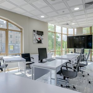 Contemporary minimalist office with glass windows and ergonomic chairs.