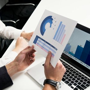 Business professionals discussing data charts and graphs in a modern office setting.