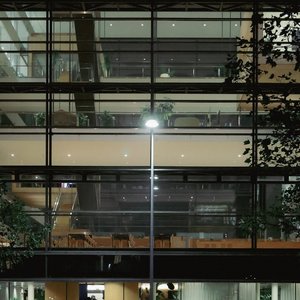 Night view of a modern glass office building in Copenhagen showcasing interior lights and architecture.