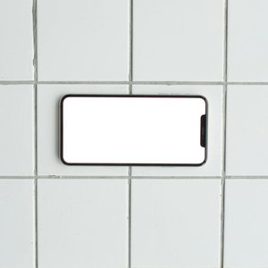 A blank smartphone mockup placed on a clean tiled surface, perfect for showcasing apps or designs.