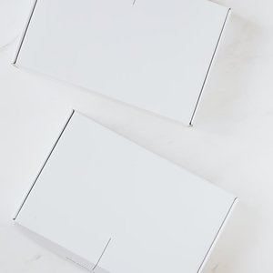 Two simple white boxes on a clean marble background. Ideal for product mockups.