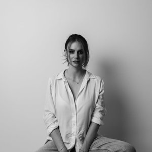 Artistic black and white portrait of a confident individual in a relaxed pose.