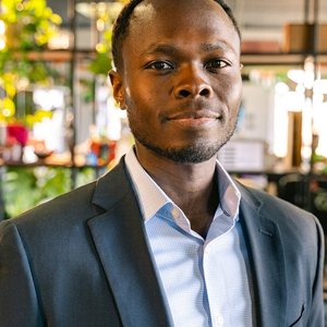 Portrait of a smiling man in a elegant black suit, indoors.