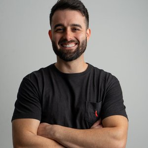 Smiling man in a casual black shirt posing for a professional portrait.