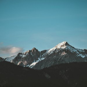Stunning view of snow-capped mountains against a blue sky, perfect for nature lovers.