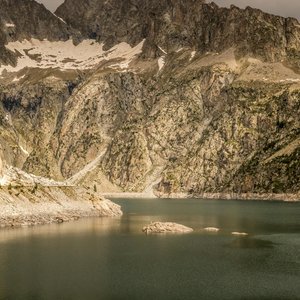 Majestic view of the rugged mountains and tranquil lake in Aragnouet, France.
