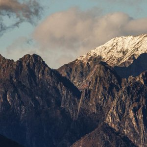 A stunning view of snow-capped mountains with a dramatic sky backdrop.