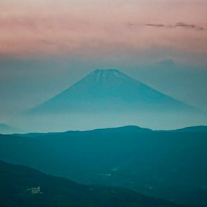 Tranquil scene capturing Mount Fuji shrouded in mist during dusk from Itō, Japan.