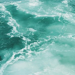 Dynamic teal ocean waves showcasing foamy textures and vibrant movement.