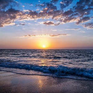 Captivating sunset over the ocean with vibrant colors, serene waves, and a peaceful sky.