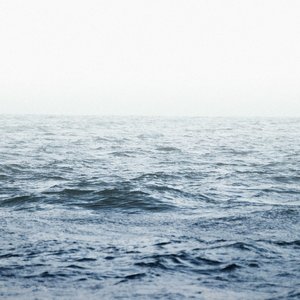 A serene view of ocean waves rolling under a calm, foggy sky, showcasing nature's tranquility.