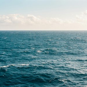 Tranquil ocean view under a clear sky, capturing the serene beauty of the expansive water.