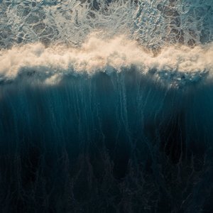 Stunning aerial capture of ocean waves crashing and creating a mesmerizing water pattern.