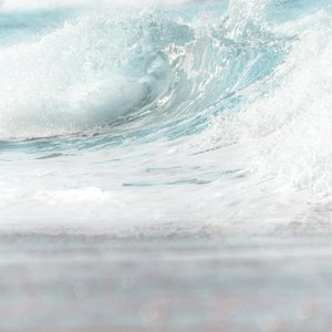 Scenic view of foamy blue sea wave rolling on shore on clear day