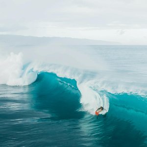 A surfer skillfully rides a large wave at Haleiwa Beach in Oahu, capturing the essence of adventure and excitement.