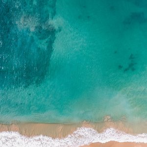 A stunning aerial shot of a beautiful beach in Dambulla, Sri Lanka with clear waters.