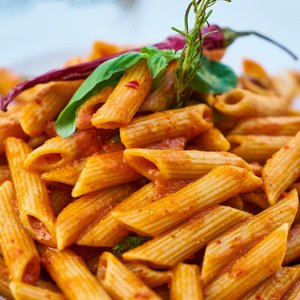 Savor the flavors of Italian cuisine with this close-up photo of tasty penne pasta in tomato sauce.