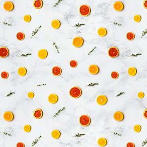 Colorful citrus slices arranged in a flat lay pattern on a marble surface, ideal for backgrounds.