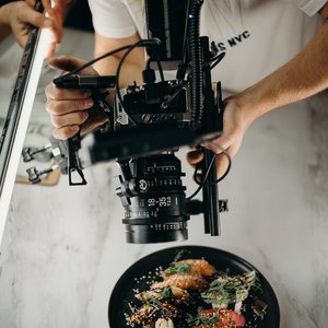 Photographer capturing a gourmet dish with high-end camera equipment from above.